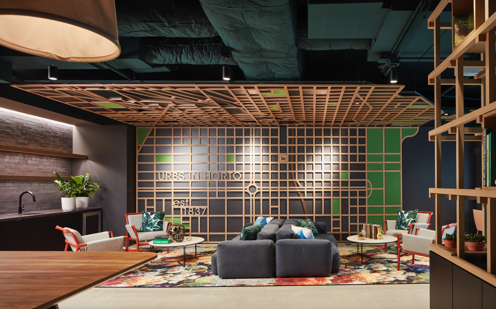 A living room with a couch , chairs , tables and a wooden ceiling.