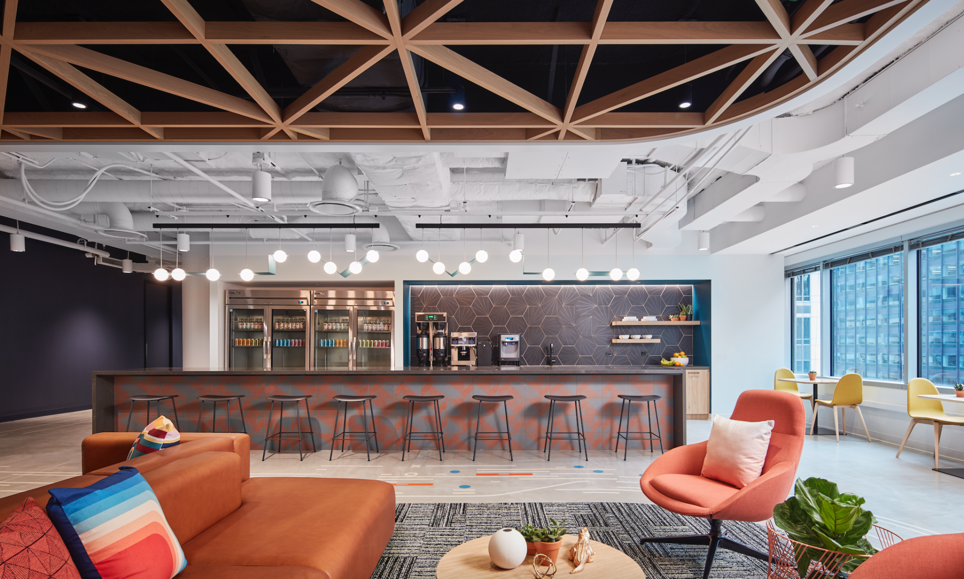 A living room with a couch , chairs , tables and a bar.