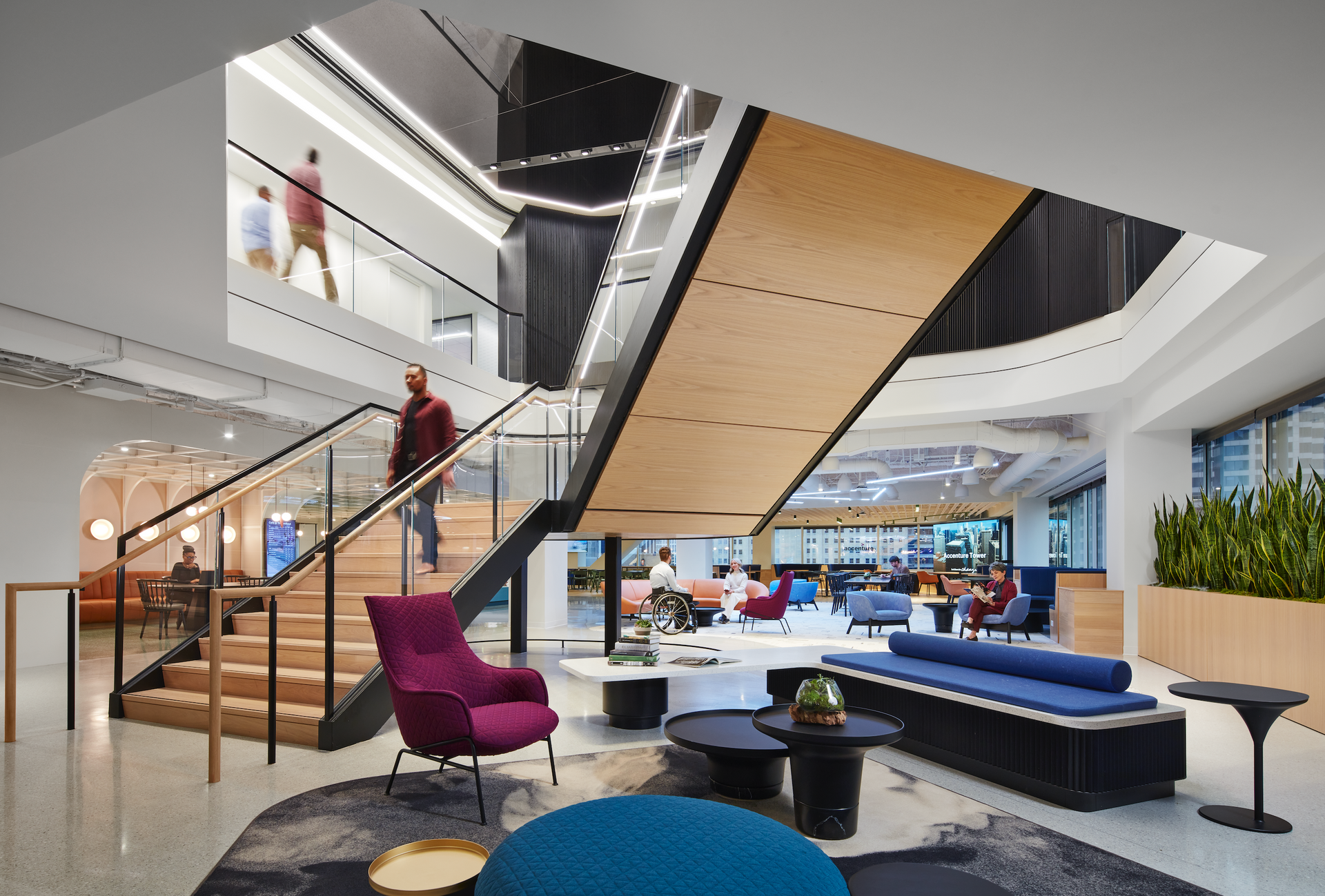 A man is walking down a set of stairs in a large room.