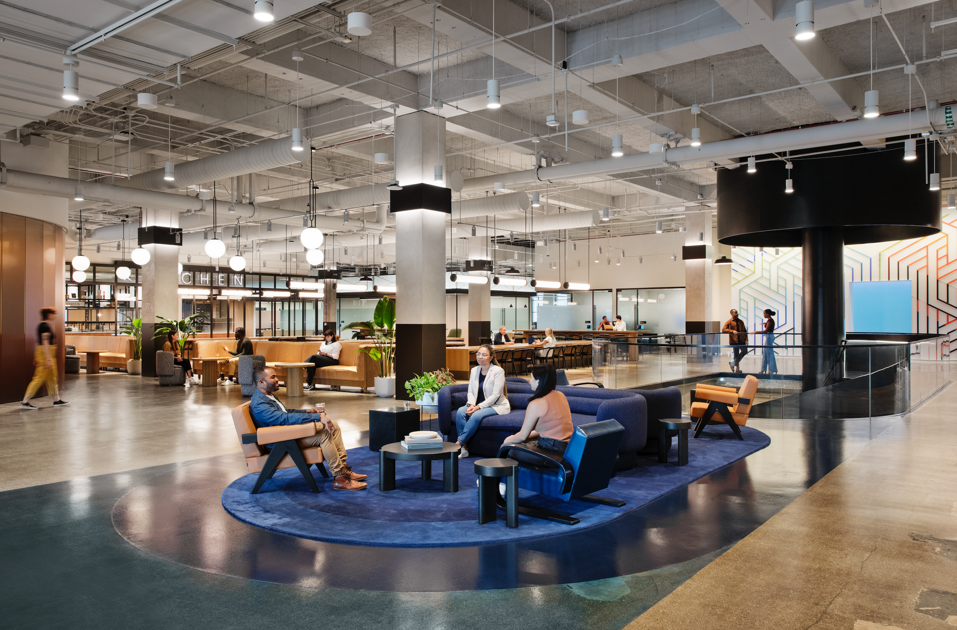 A group of people are sitting on a couch in a large room.