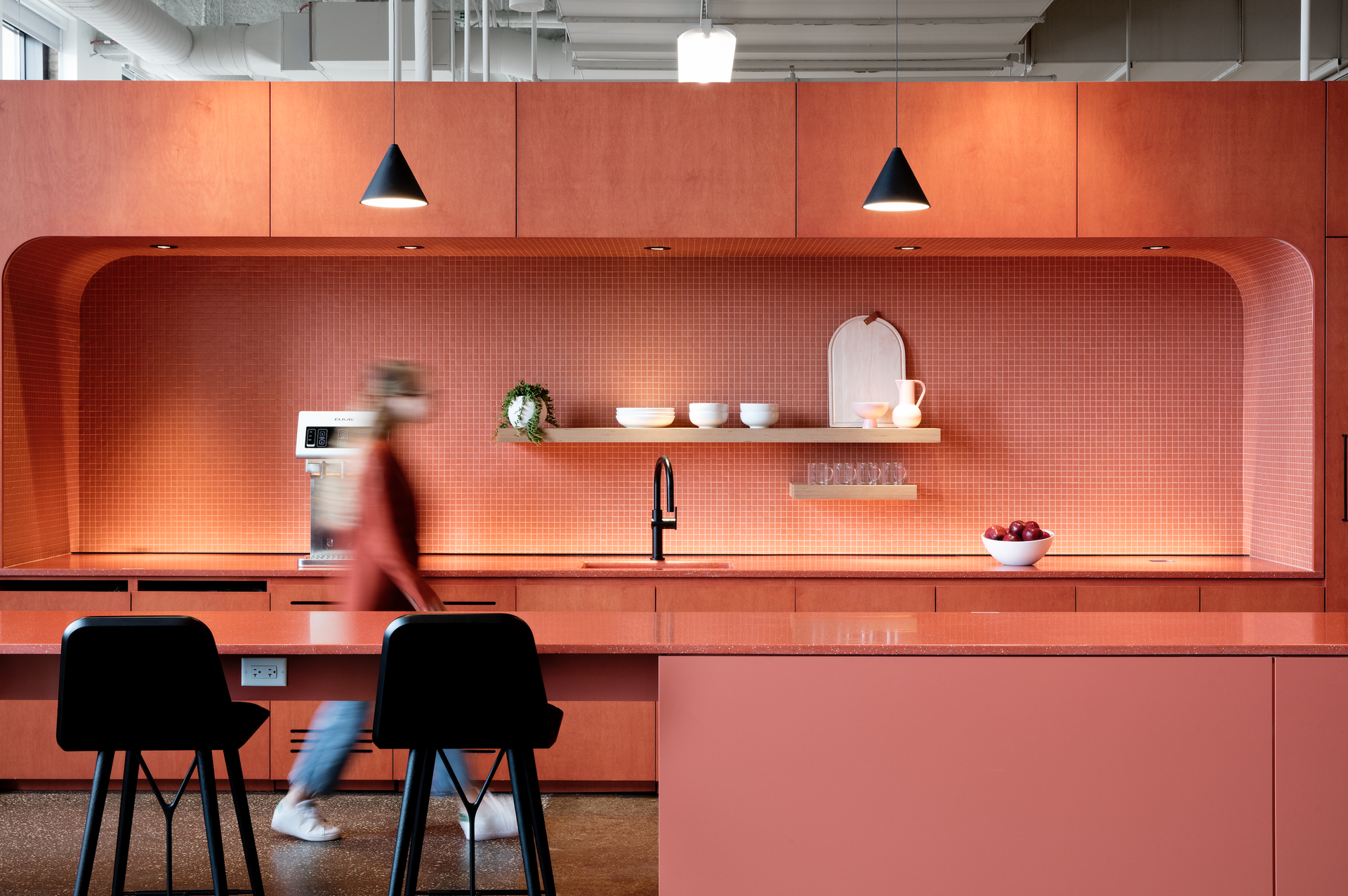 A blurry picture of a person walking in a kitchen.
