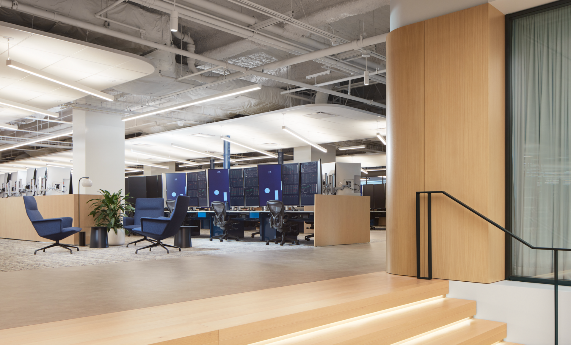 A large open office with stairs leading up to it.