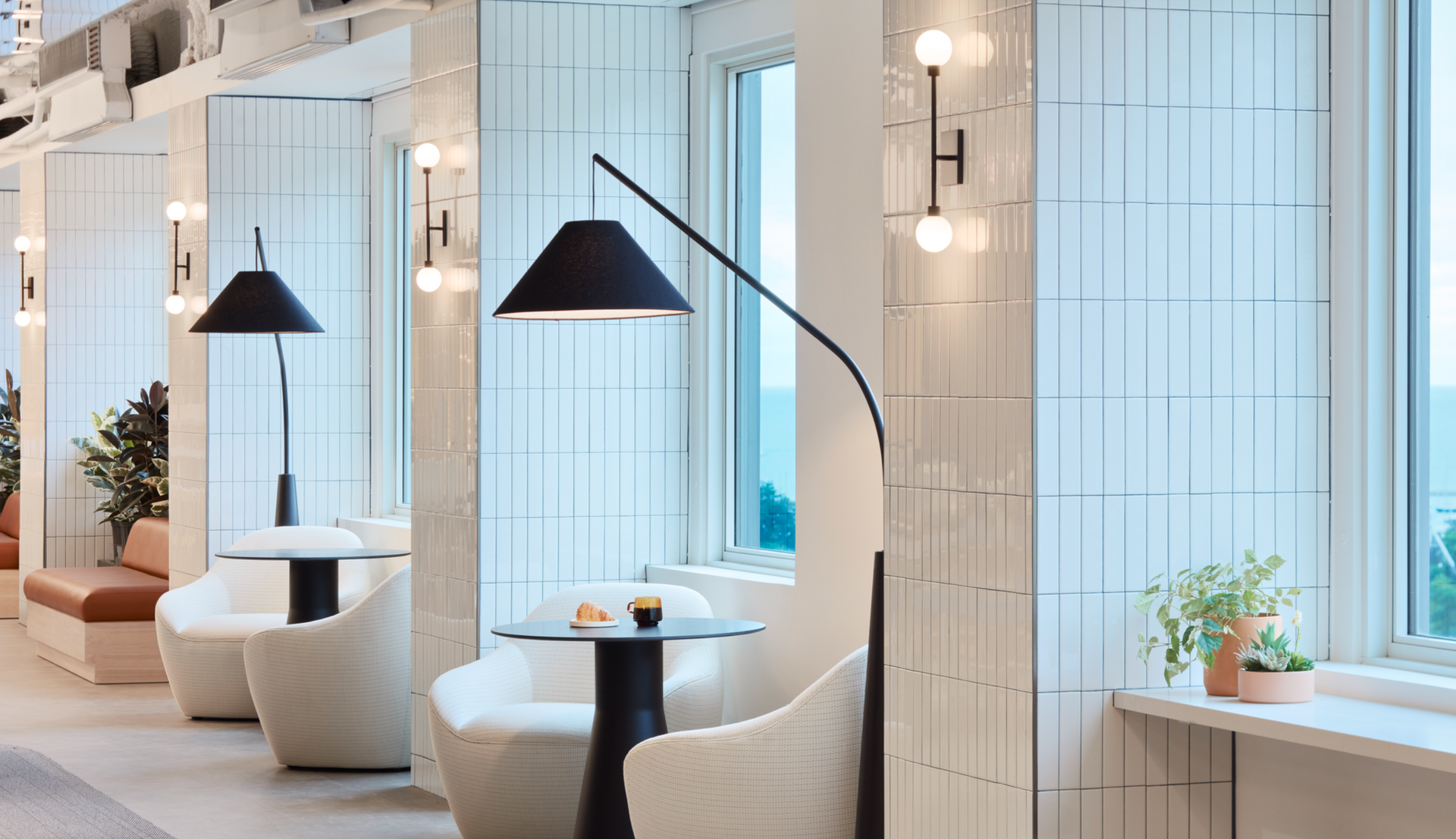 A row of chairs and tables in a room with a lamp.