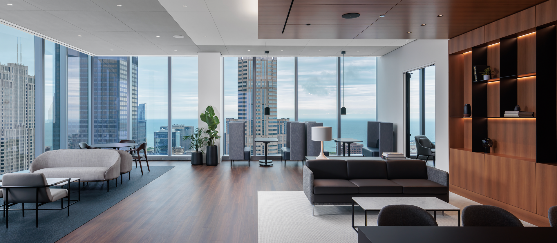 A living room with a couch , chairs , and a table with a view of the city.