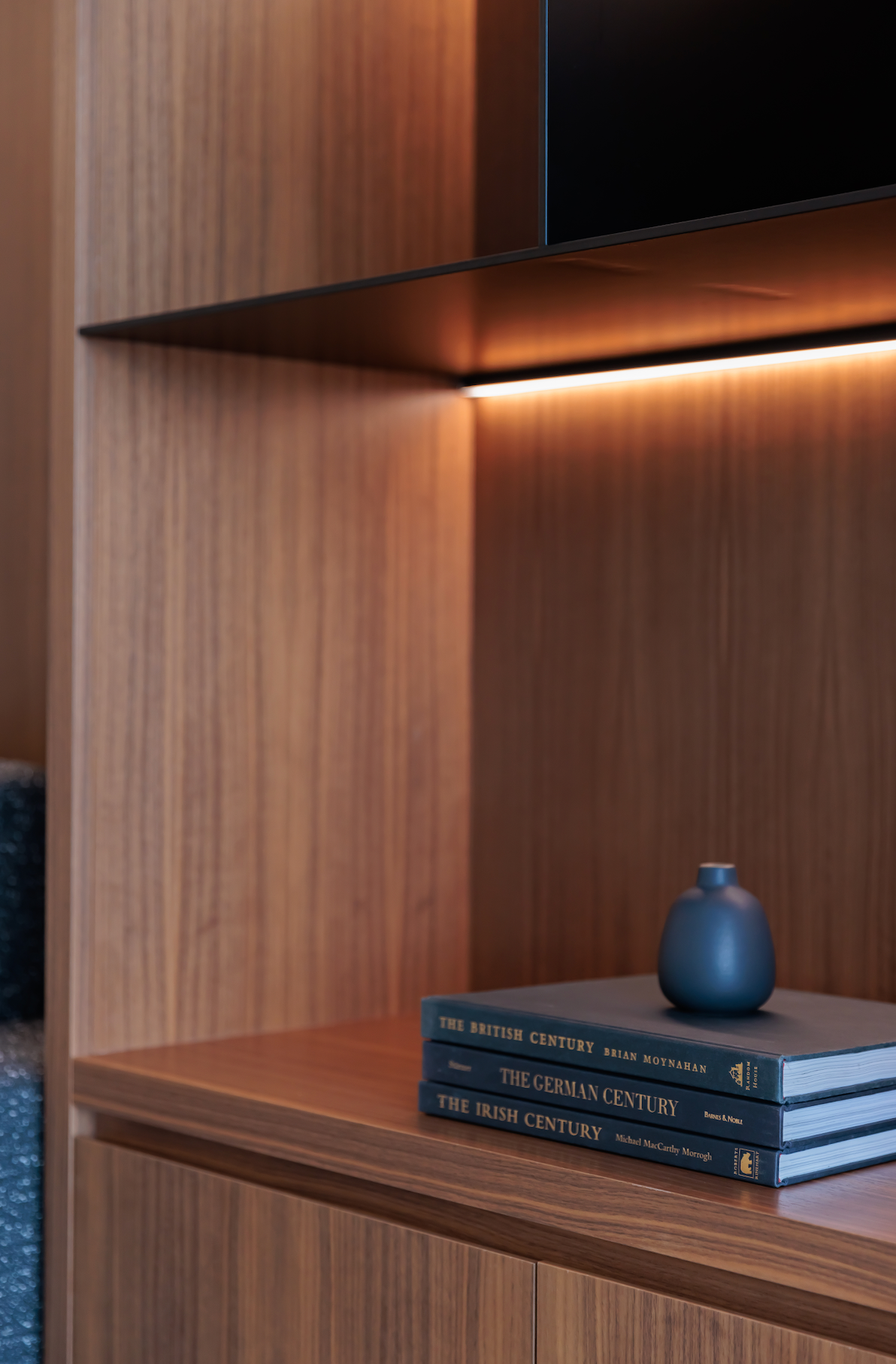 A stack of books sitting on top of a wooden shelf.