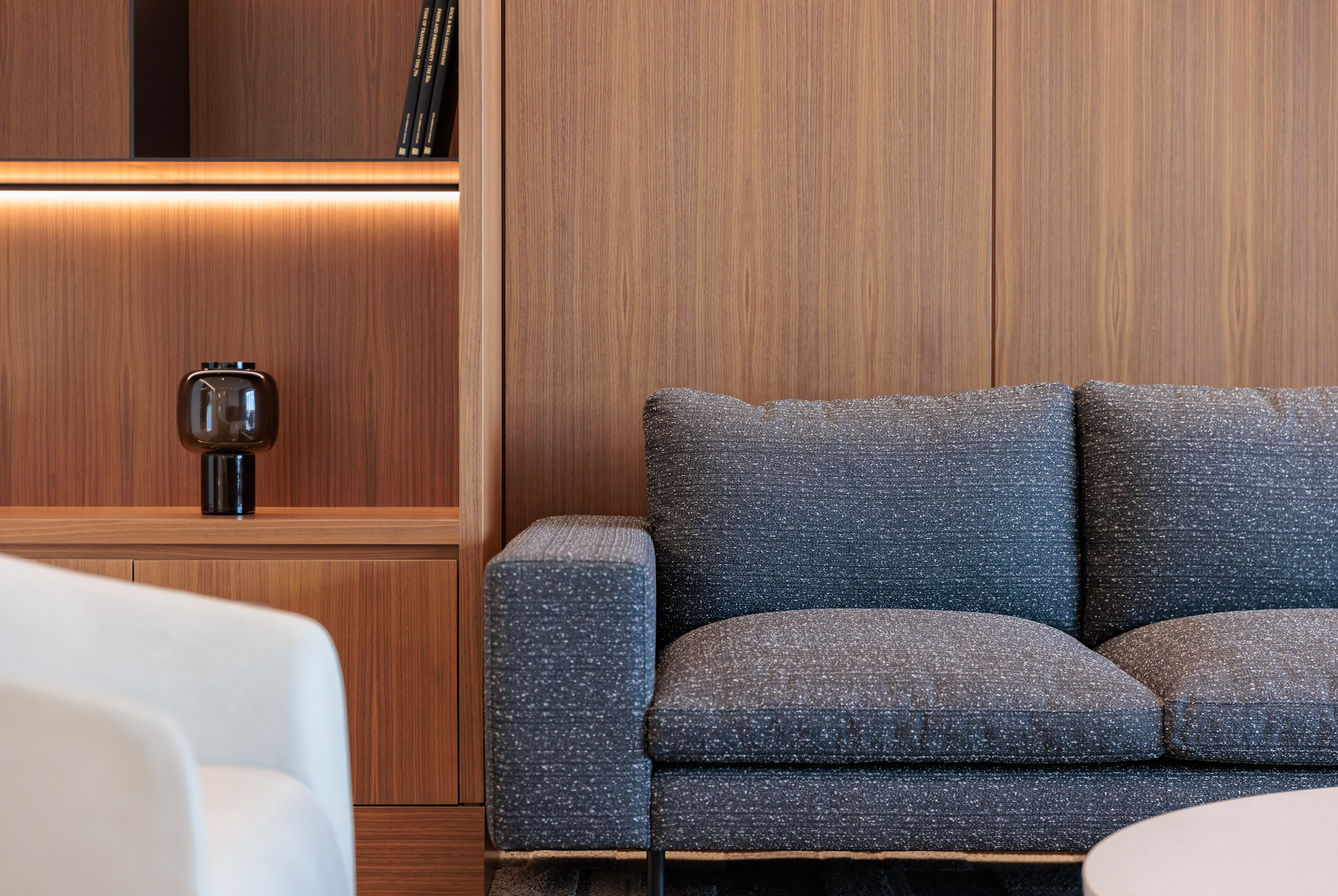 A living room with a couch , chair , table and bookshelf.