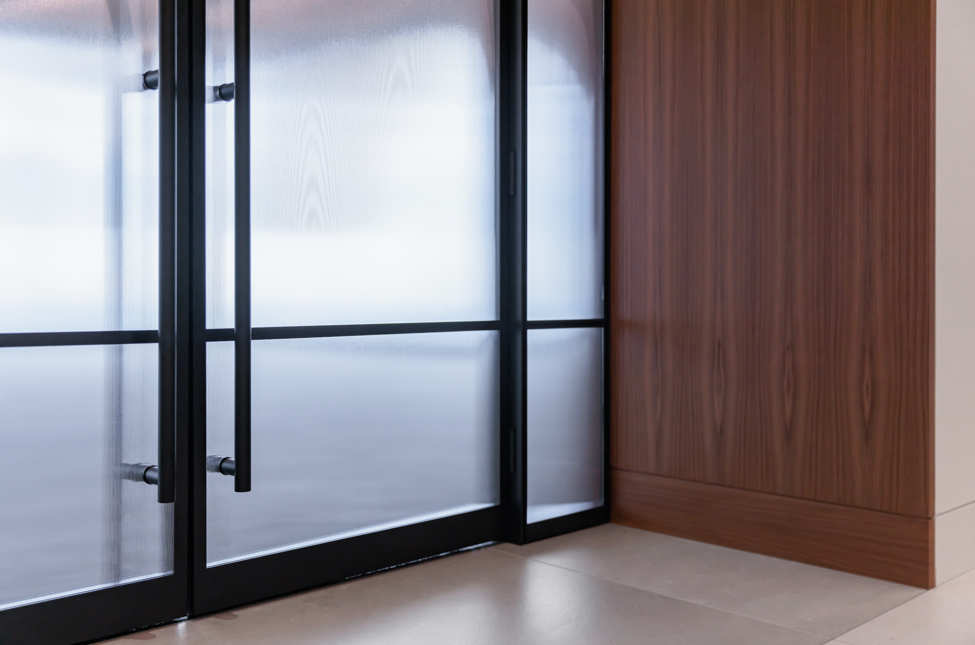 A room with a glass door and a wooden wall.