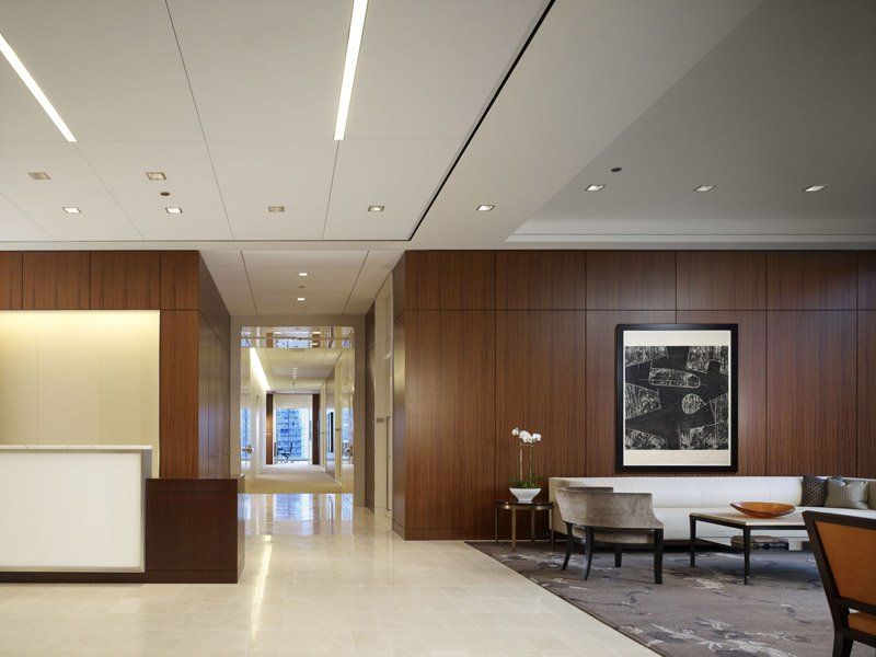 A lobby with a couch and chairs and a painting on the wall