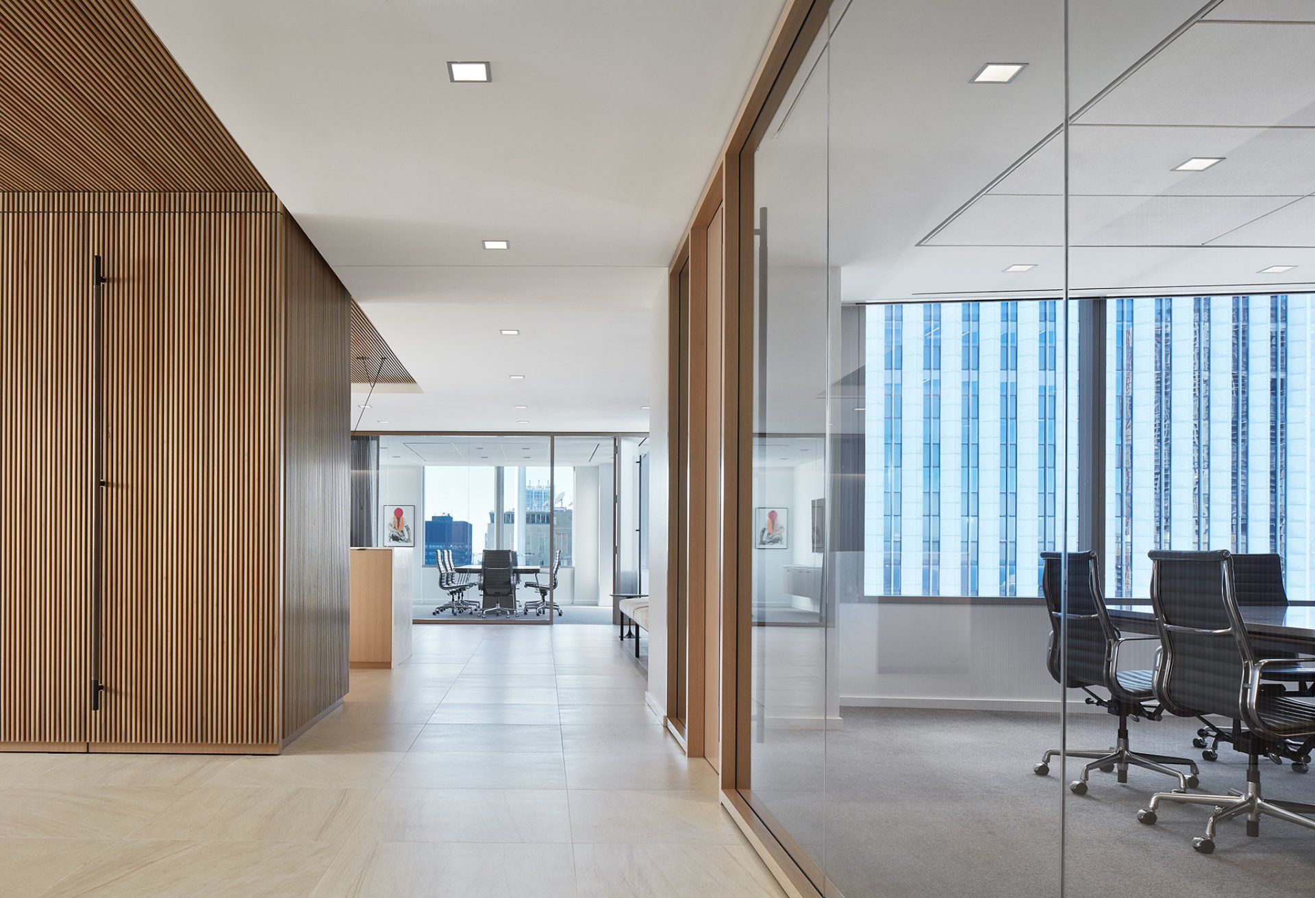 A conference room with a glass wall and chairs in it.