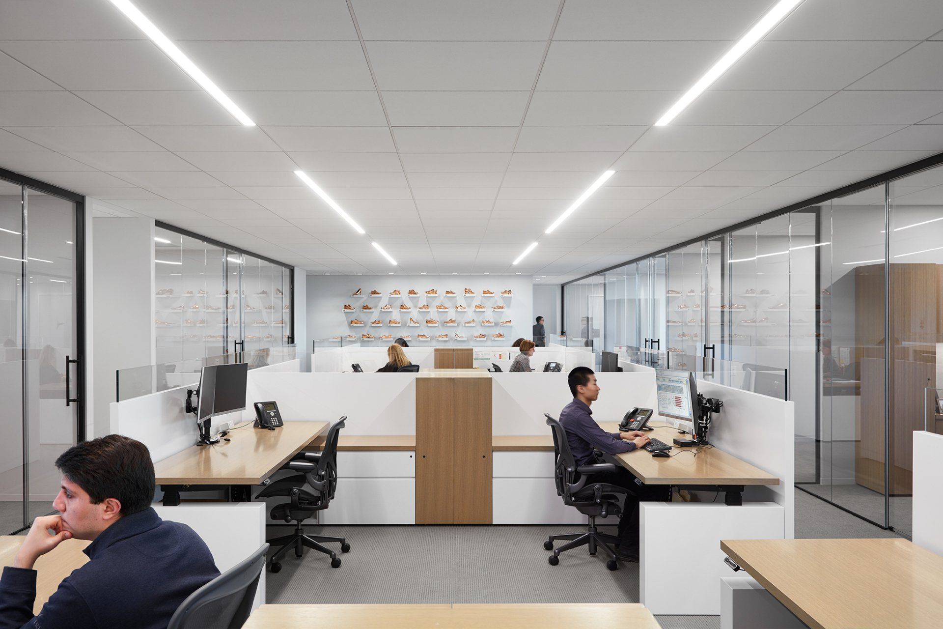 A man is sitting at a desk in an office cubicle.