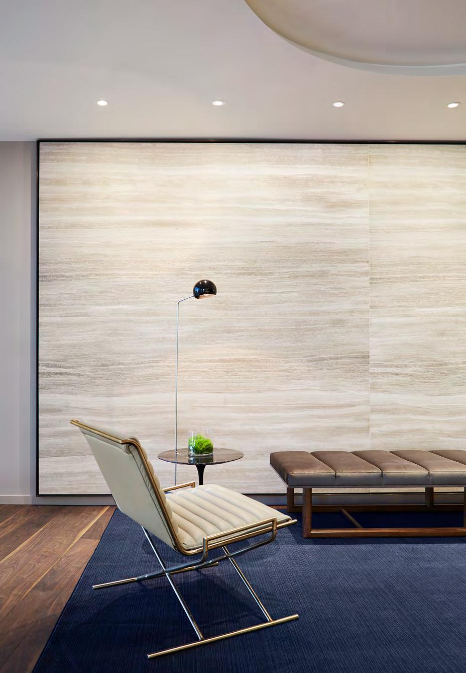 A chair is sitting in front of a large wall in a living room.