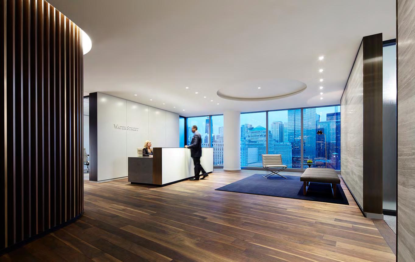 A man is standing at a reception desk in a lobby.