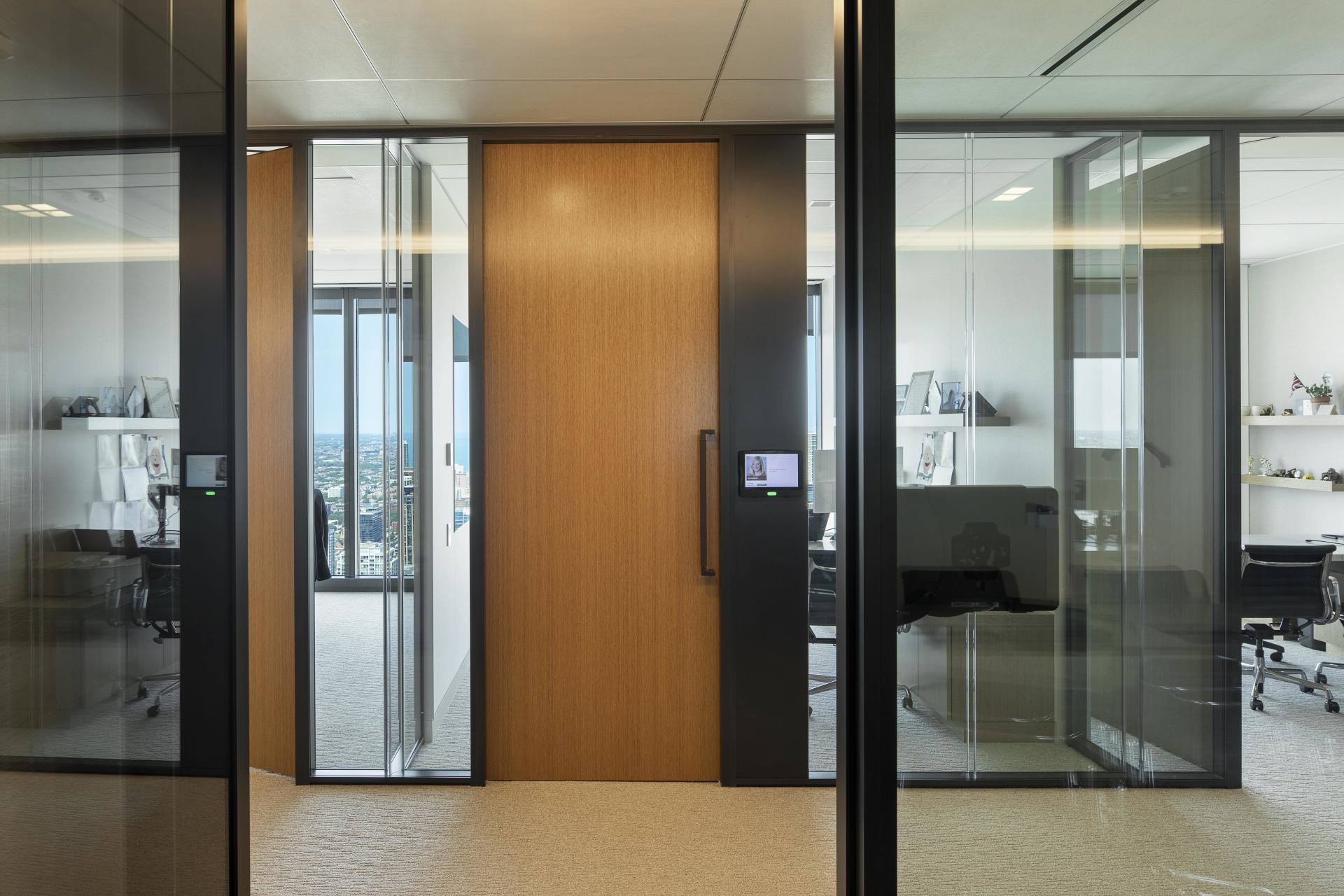 A room with a wooden door and glass walls.