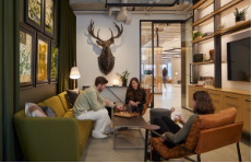 A group of people are sitting around a table in a living room.