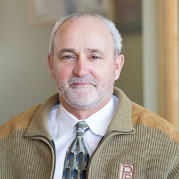 A man with a beard is wearing a jacket and tie.