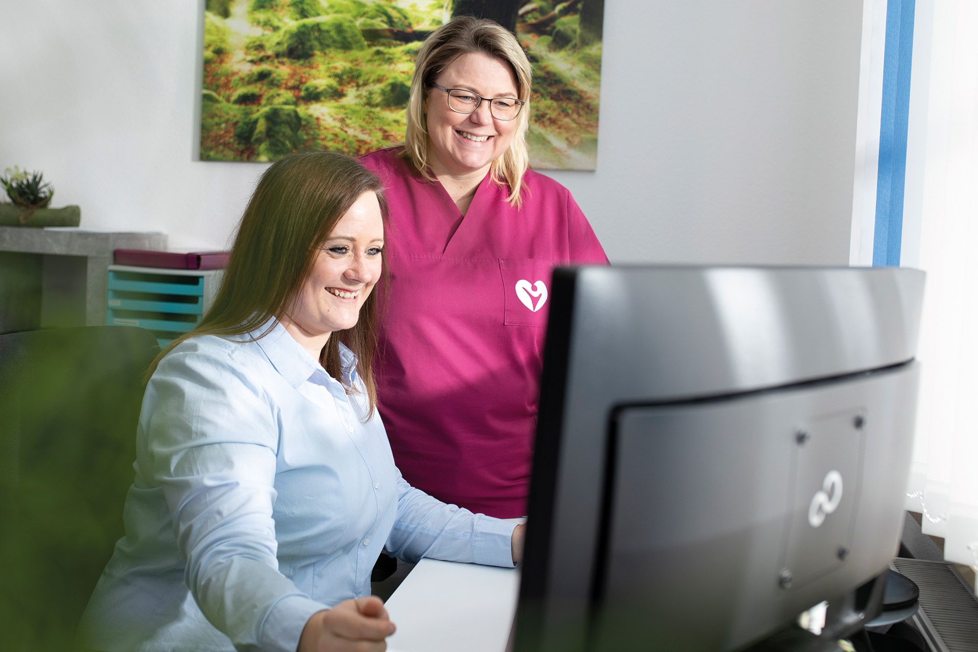 PFLEGERWOHL Mitarbeitergewinnung Zwei Pflegekräfte schauen auf einen Bildschirm 