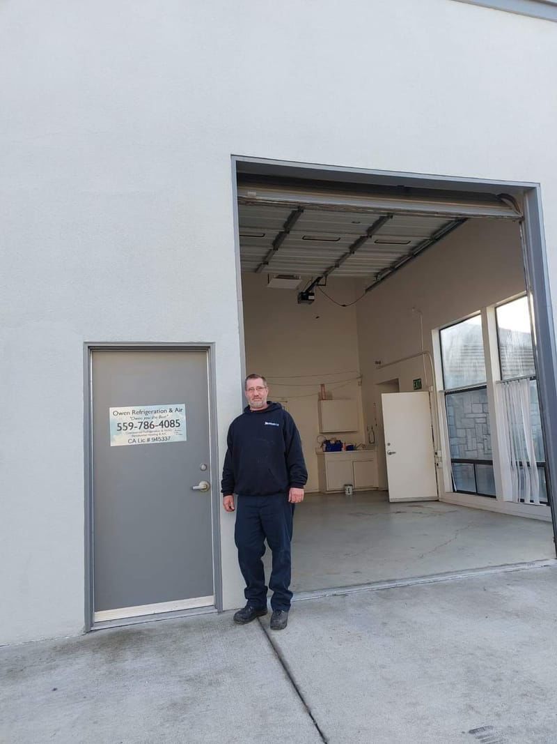 A man is standing in front of a garage door.