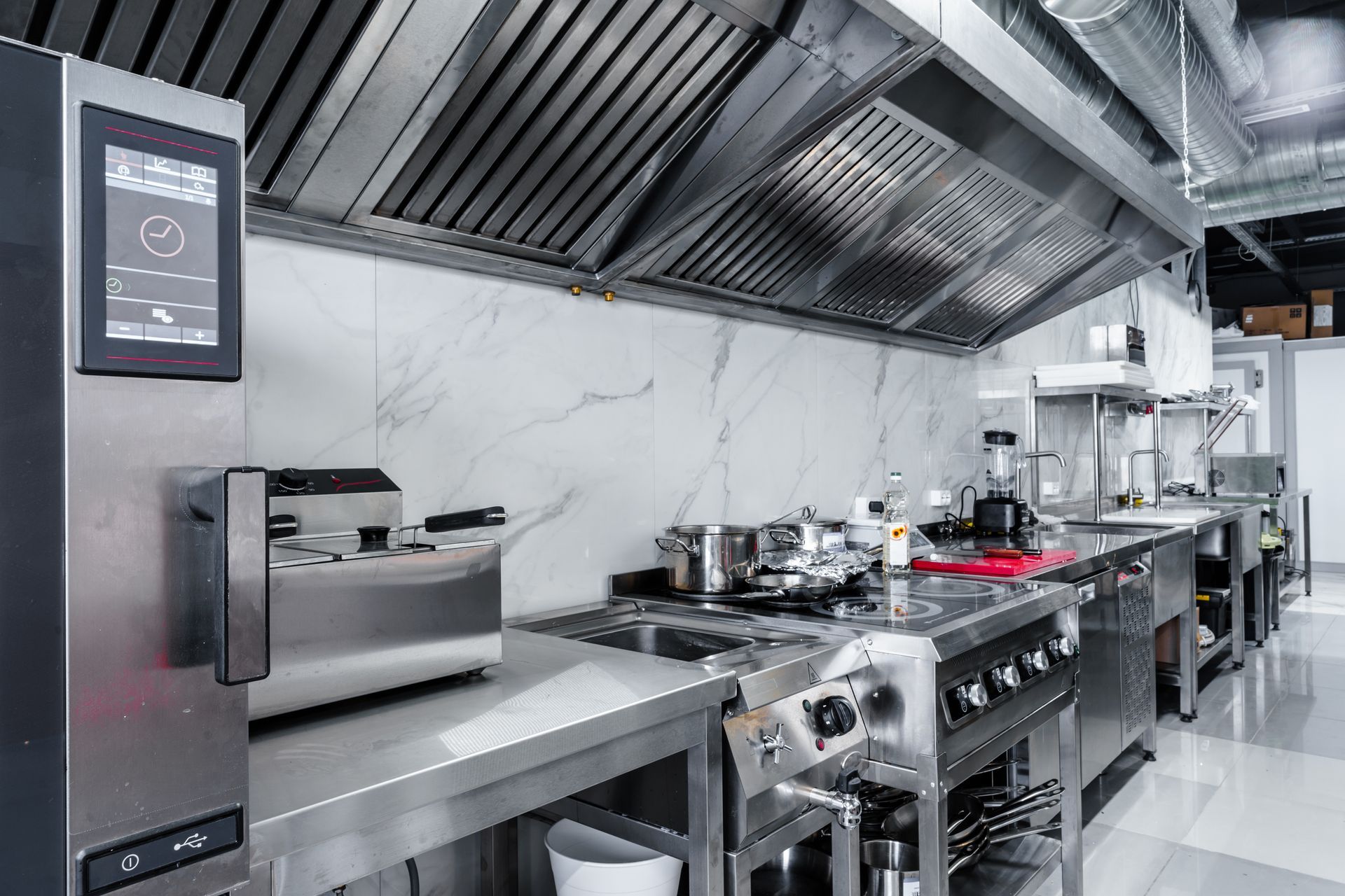 A kitchen with stainless steel appliances and a hood.