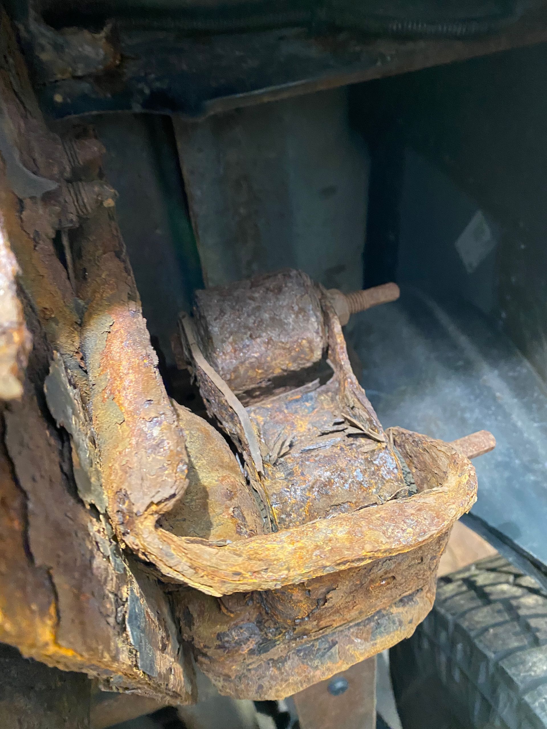 A close up of a rusty piece of metal on a car.