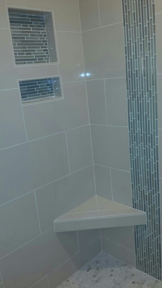 A shower with a corner shelf and two shelves.