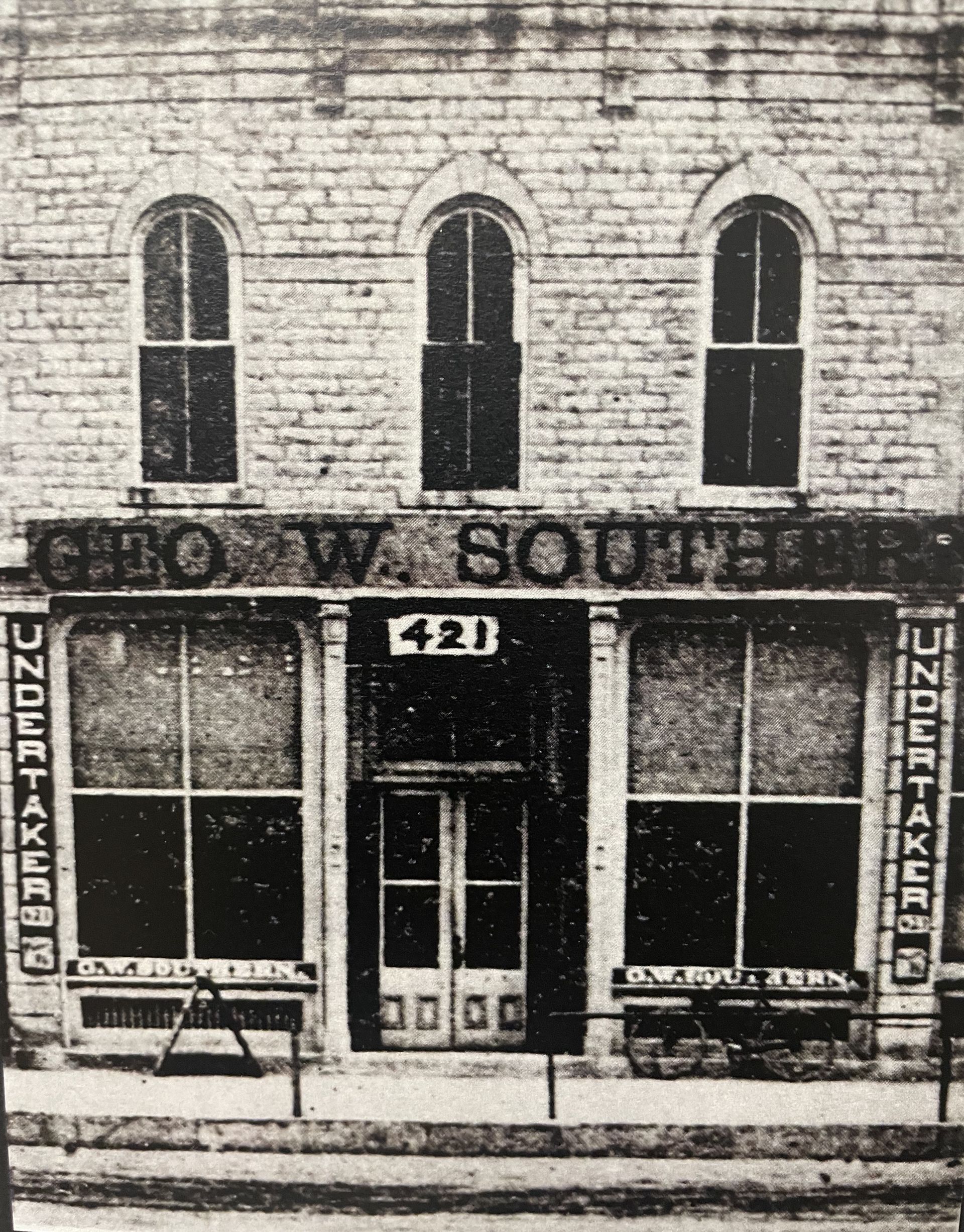 A black and white photo of a building with the number 420 on it