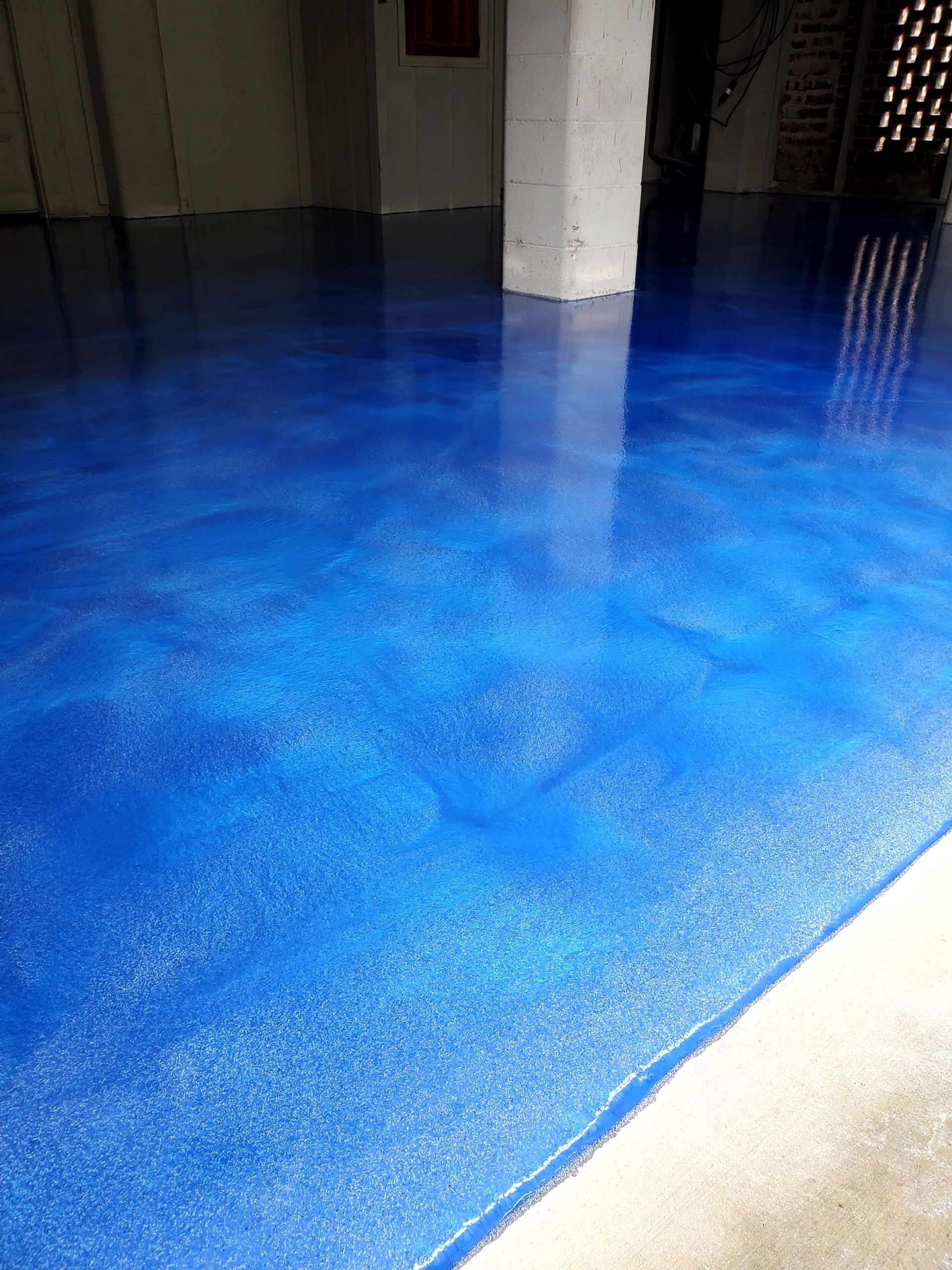 Hand with a spacer, placing it between tiles on a floor, near tile leveling wedges.