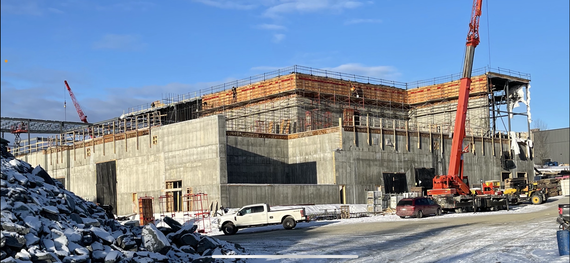 Un grand bâtiment est en construction sous la neige.