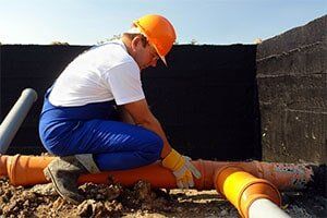 Plumber at work — Drain Cleaning Services in Michigan