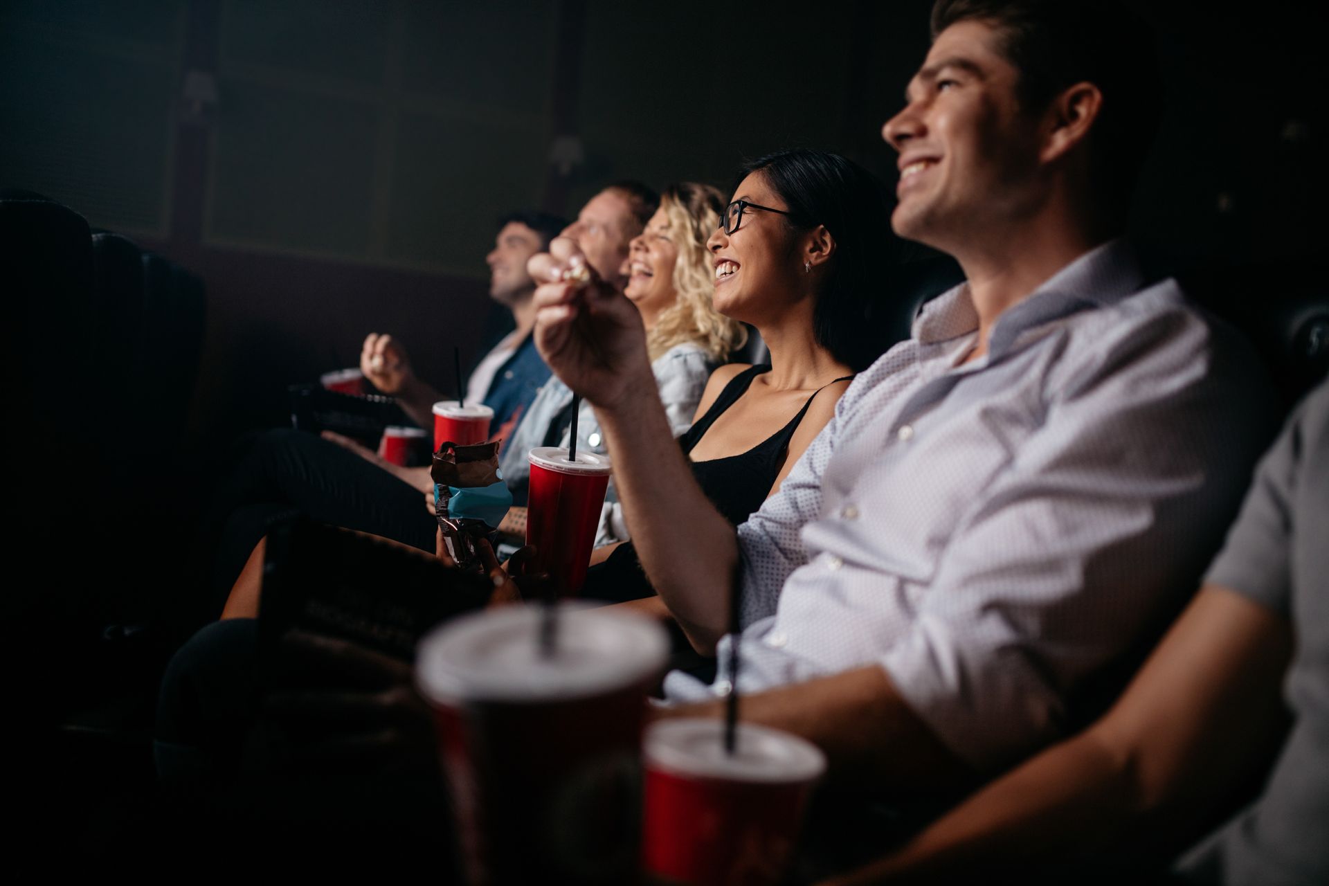 A group of people are sitting in a theater watching a movie.