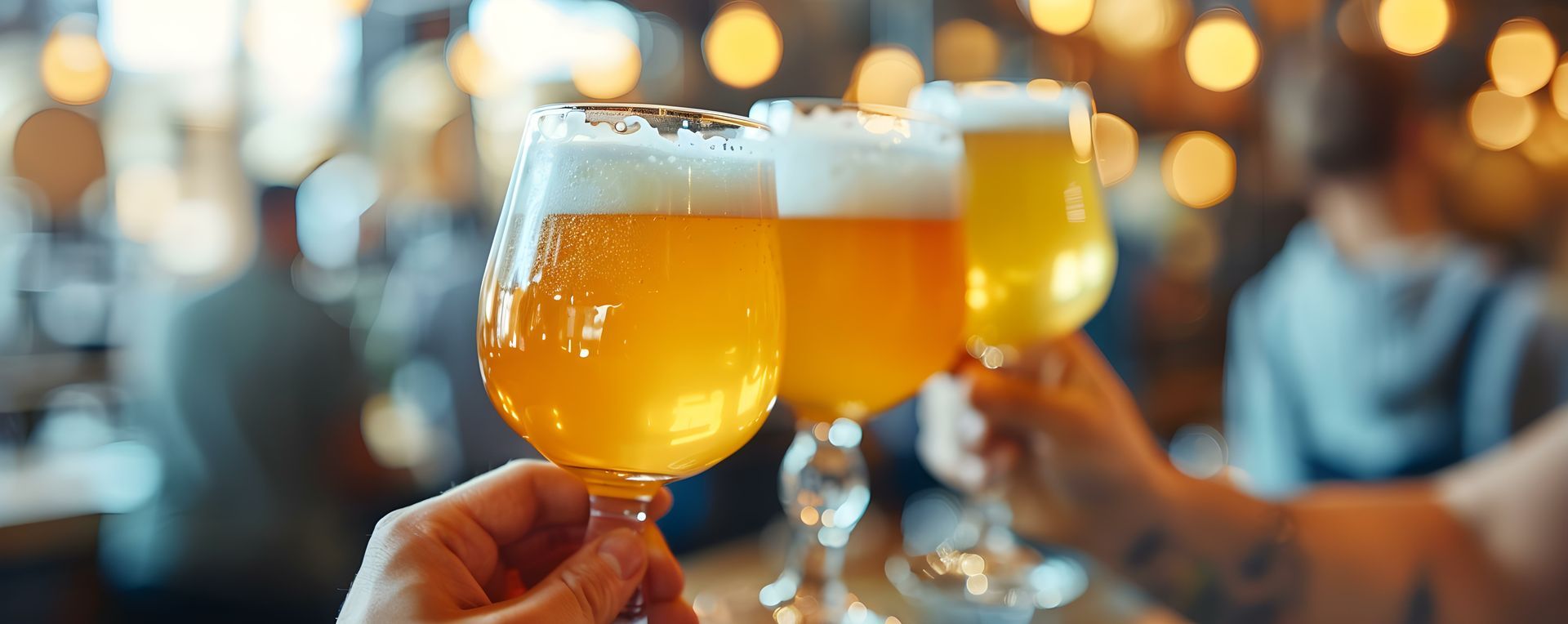 A group of people are toasting with three glasses of beer.