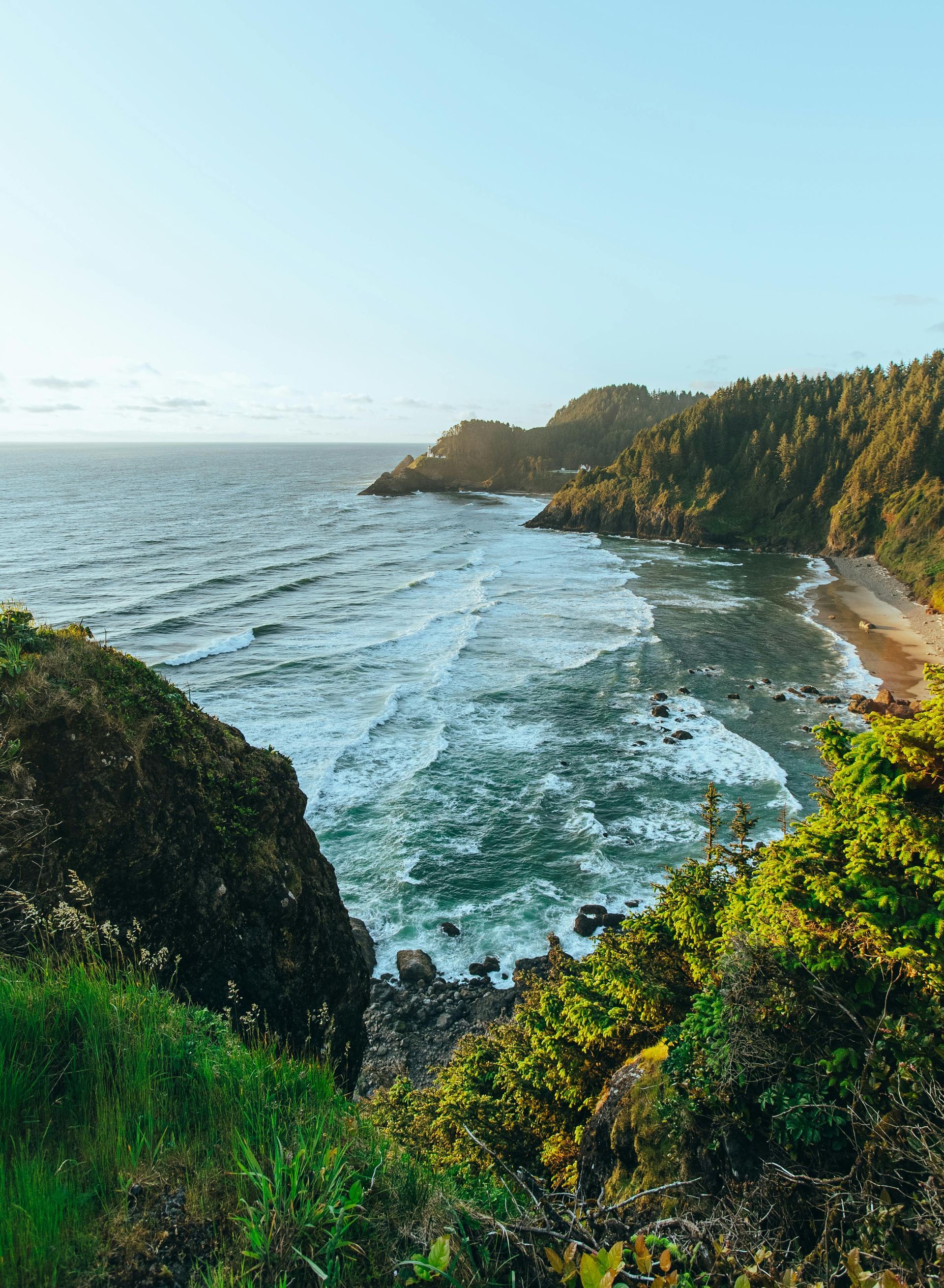 A view of a beach from a cliff overlooking the ocean.