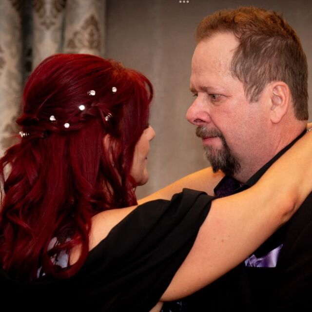 A man and woman are hugging and looking at each other