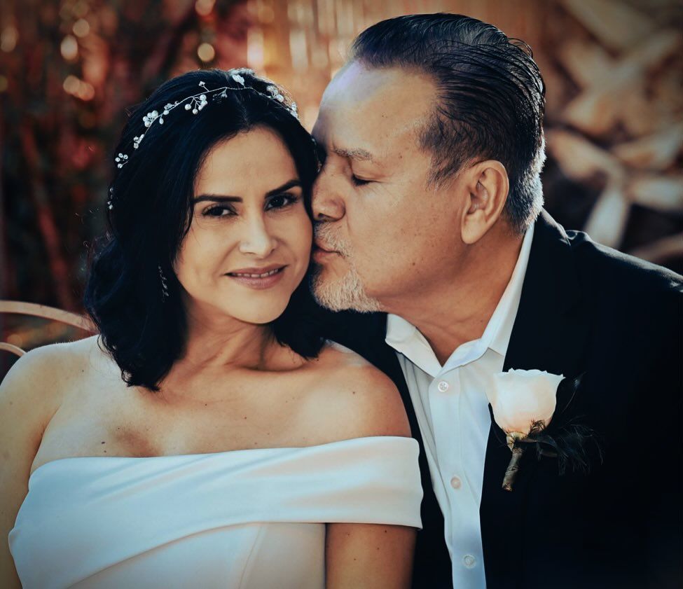 A man kissing a woman on the cheek on their wedding day