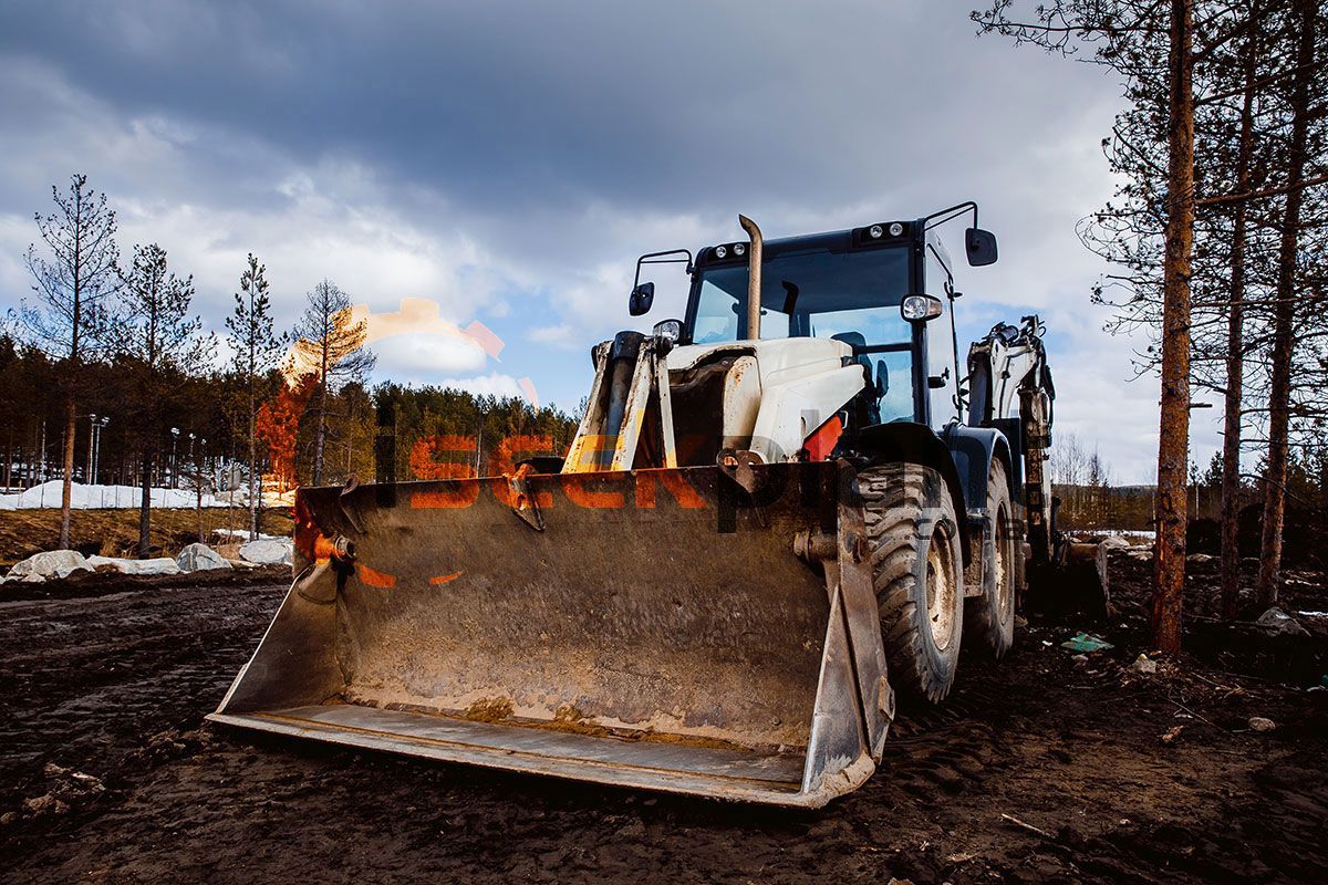 A bulldozer is parked in the middle of a forest.