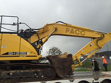 A yellow excavator is sitting on top of a trailer.