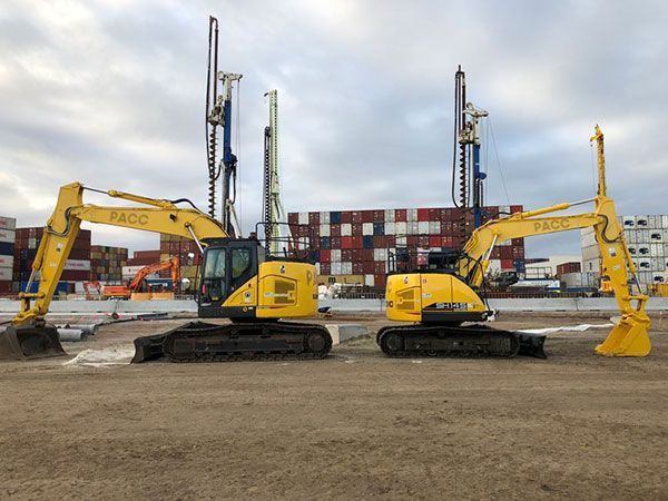 Two yellow excavators are parked next to each other in a field.