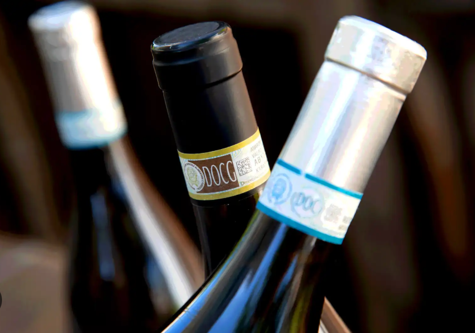 Three wine bottles with black and silver caps.