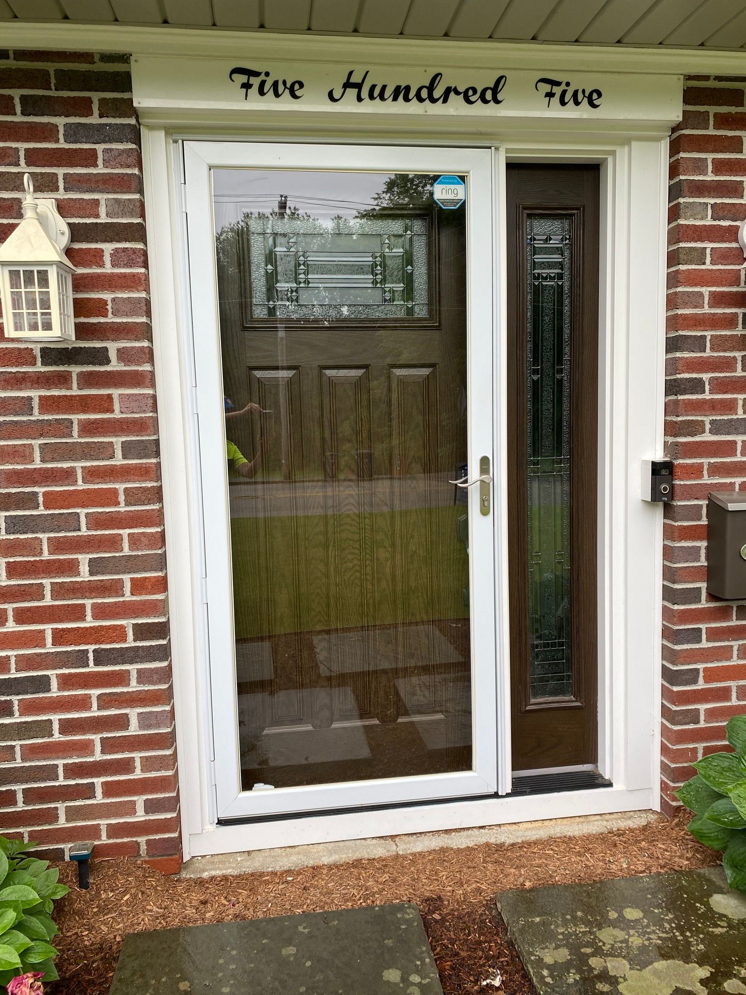 Woman in straw hat smiles, holding wine glass near a lake.