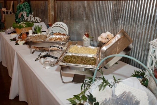 A long table with a variety of food on it.