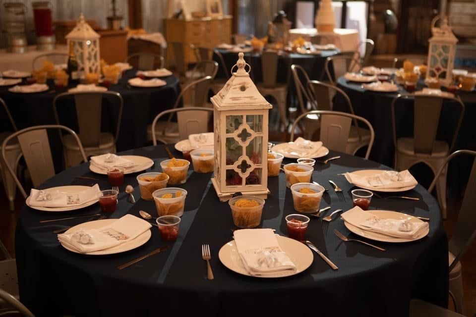 A table with plates , cups , and a lantern on it.