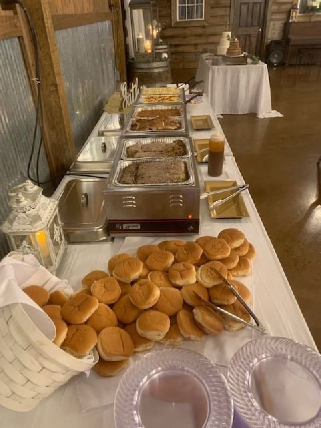 A buffet table with a bunch of hamburger buns on it.