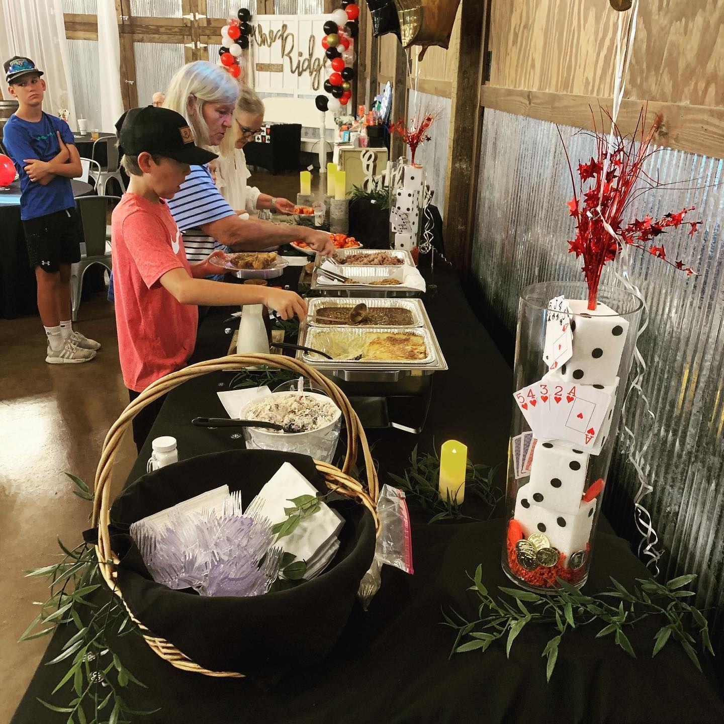 A group of people are standing around a buffet table.