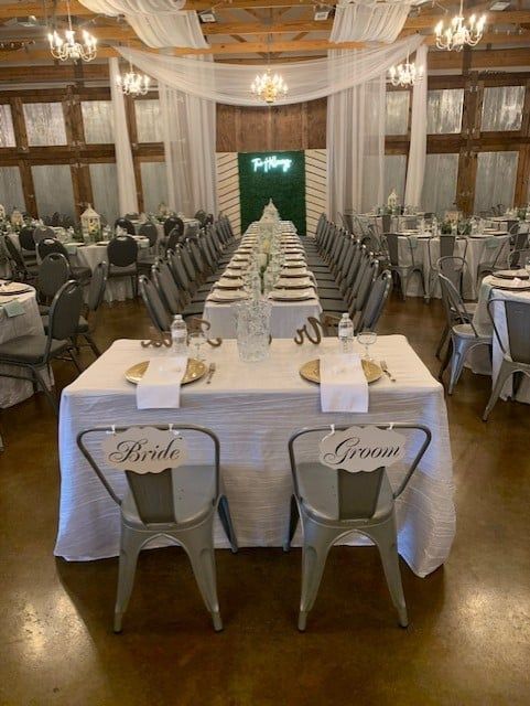 A long table with two chairs in front of it in a large room.