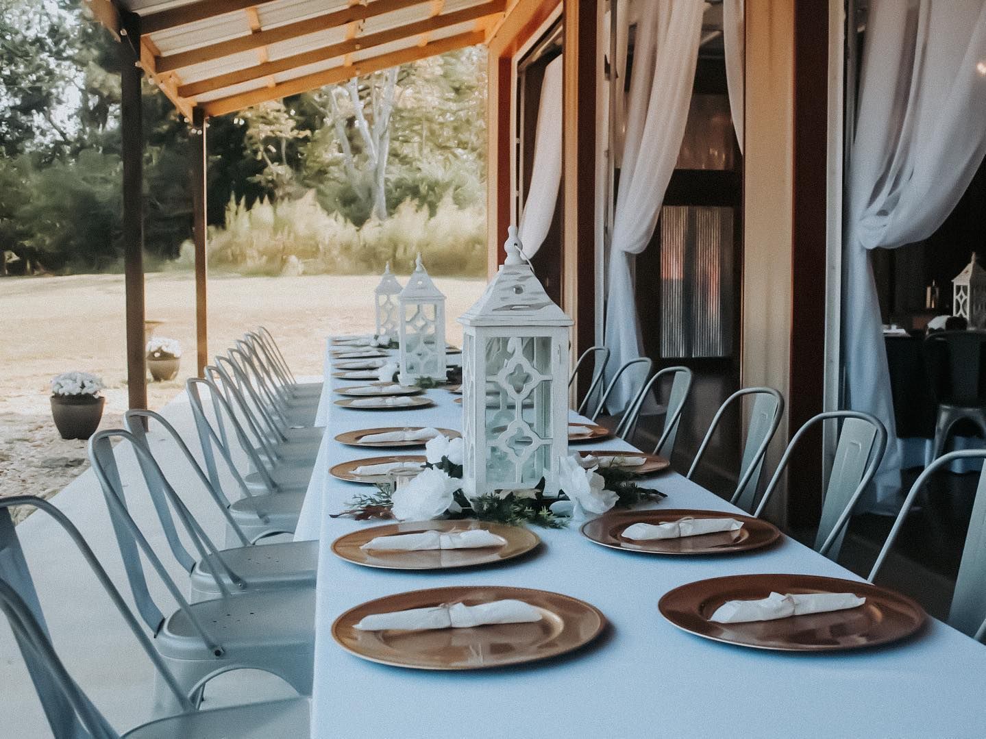 A long table with plates and lanterns on it