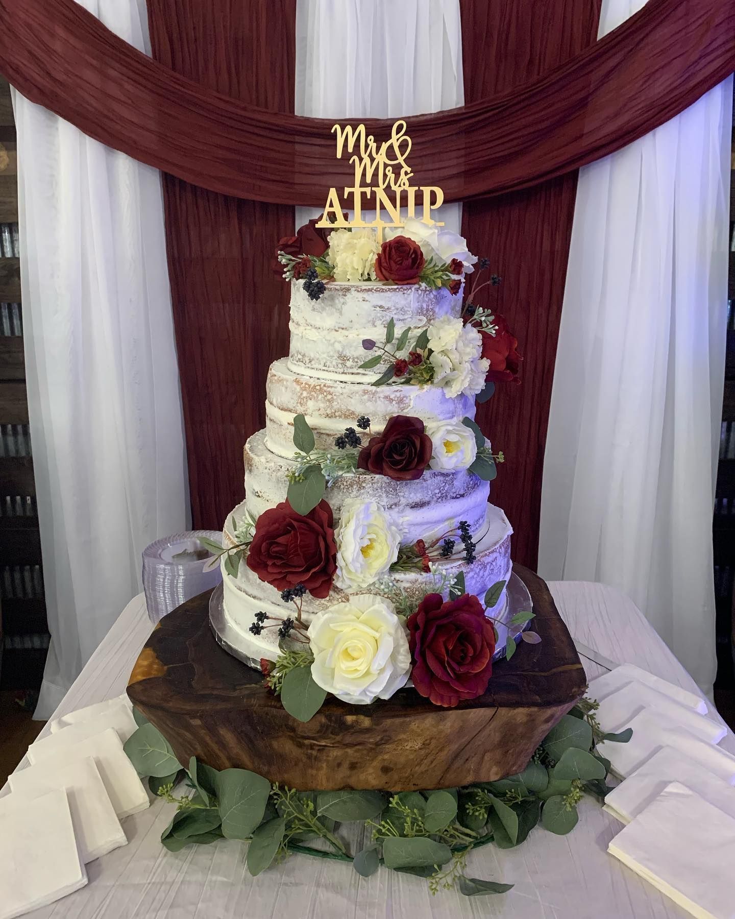 A wedding cake is sitting on top of a wooden table.