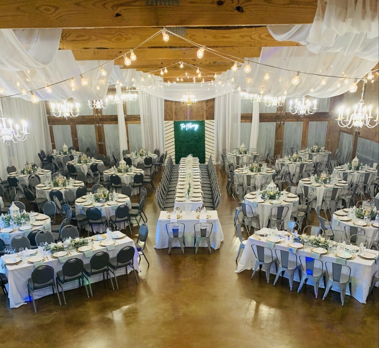 A large room with tables and chairs set up for a wedding reception.