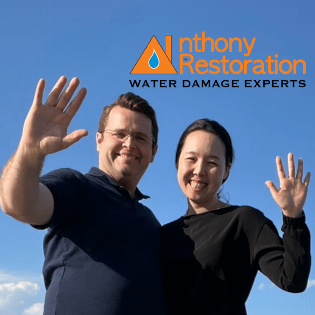 A man and a woman are posing for a picture for anthony restoration water damage experts