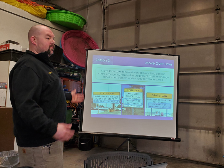 A man is giving a presentation in front of a projector screen