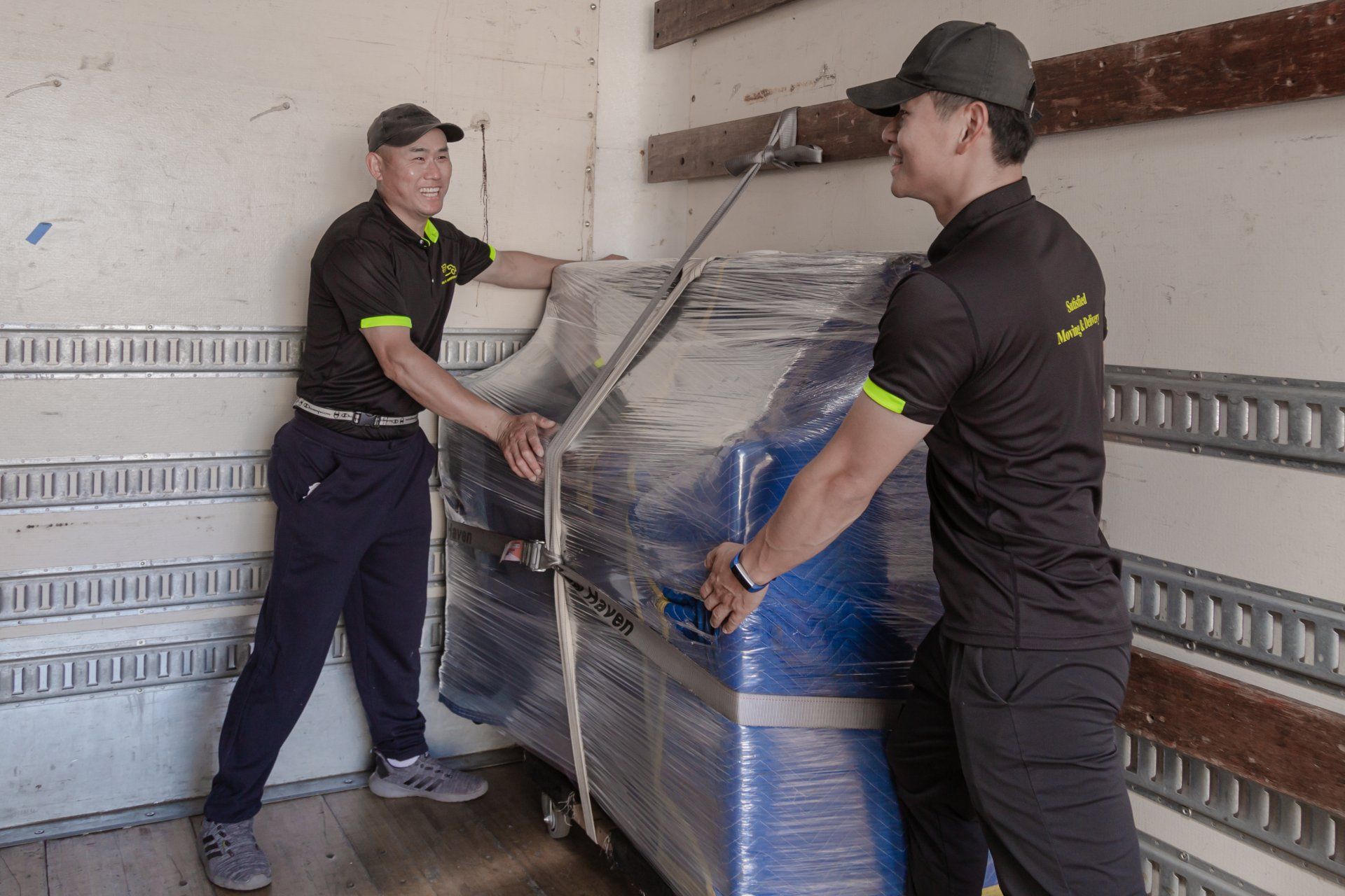 Two men are loading a machine into a truck.