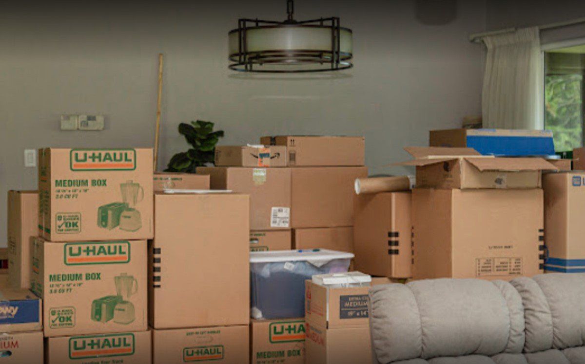 A living room filled with lots of cardboard boxes and a couch.